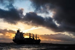 A container ship at sea at sunset.