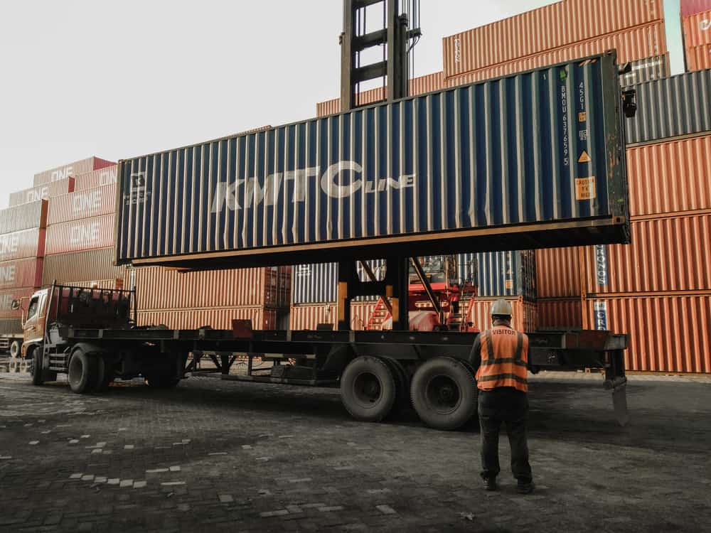 Um contêiner marítimo da Korea Marine Transport Corporation sendo carregado no convés do porto de Surabaya, Indonésia